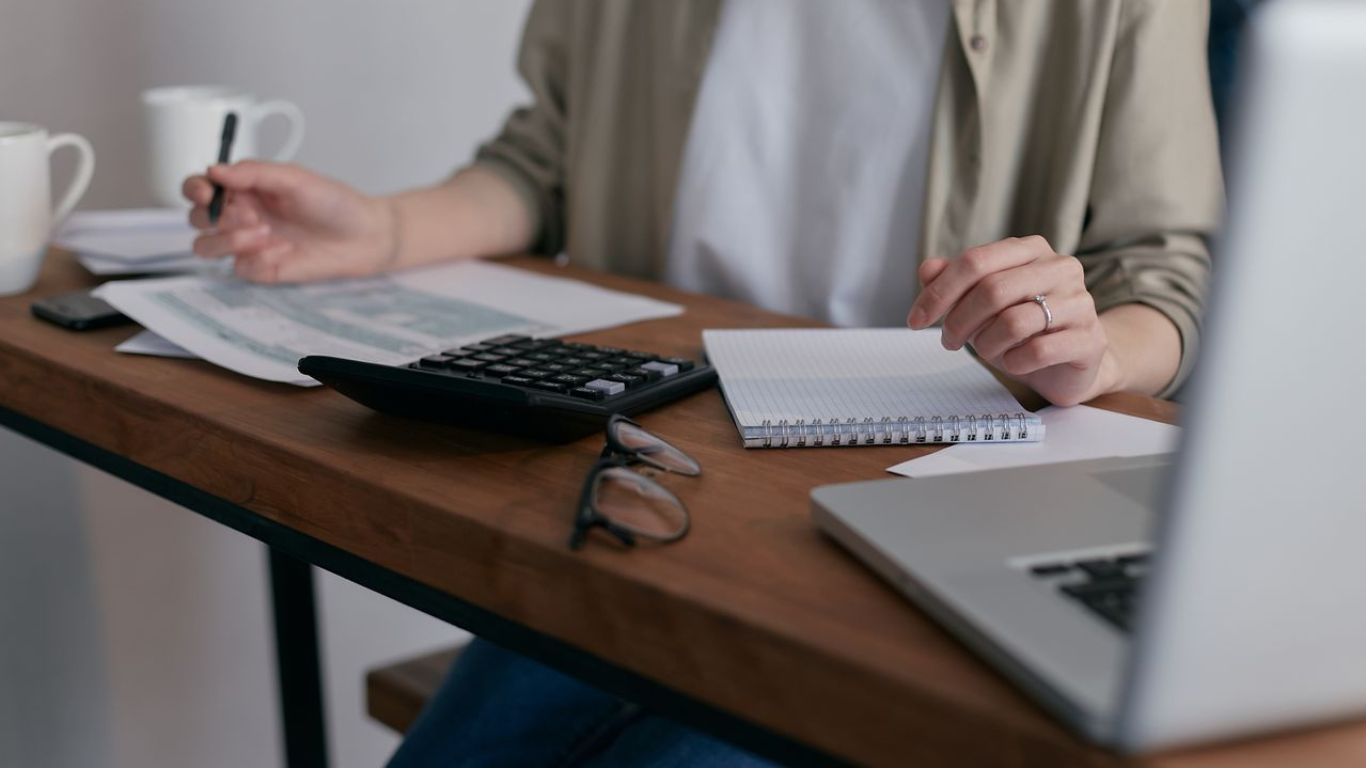Person calculating finances on an office desk