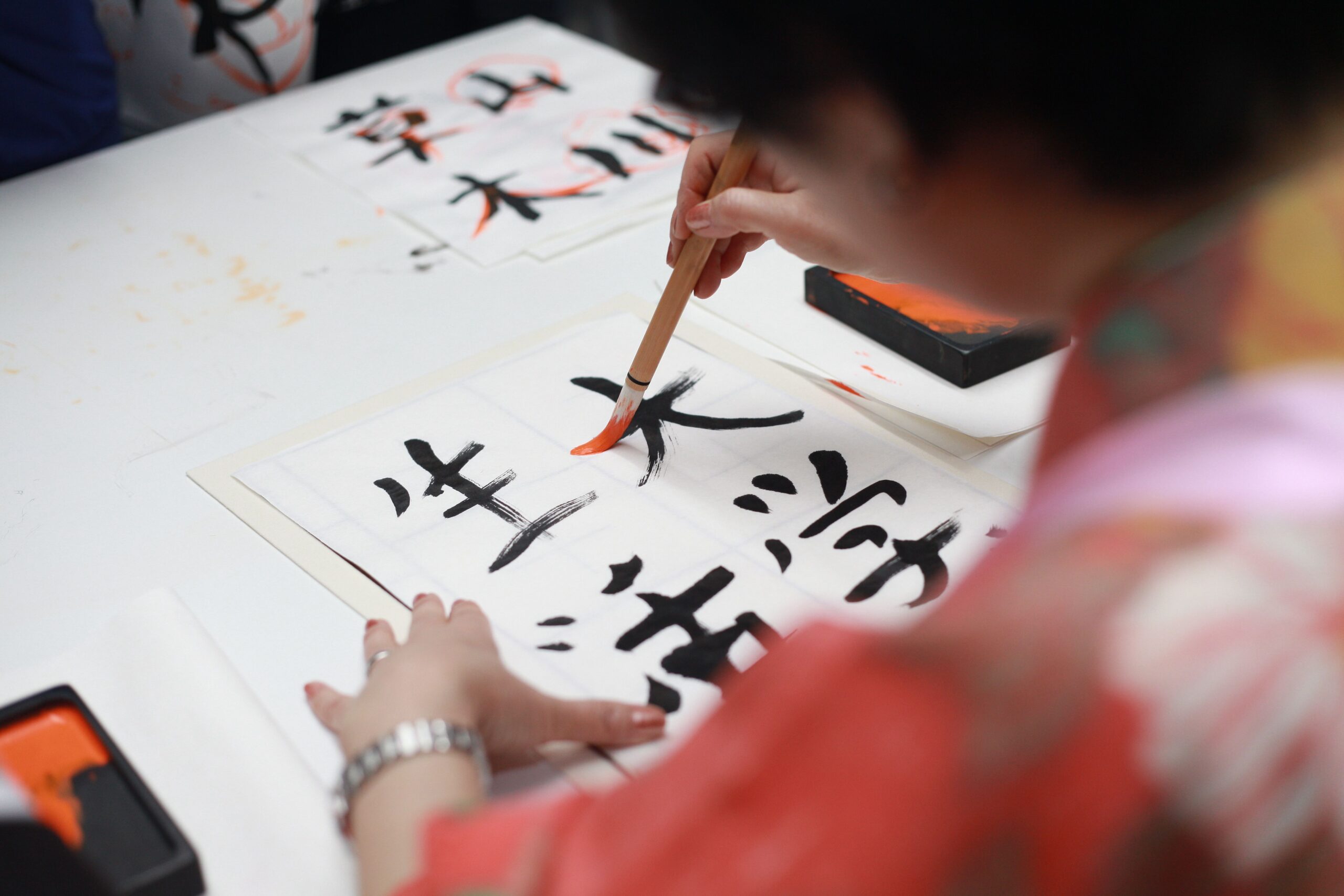 Japanese calligraphy brush writing kanji characters with traditional ink