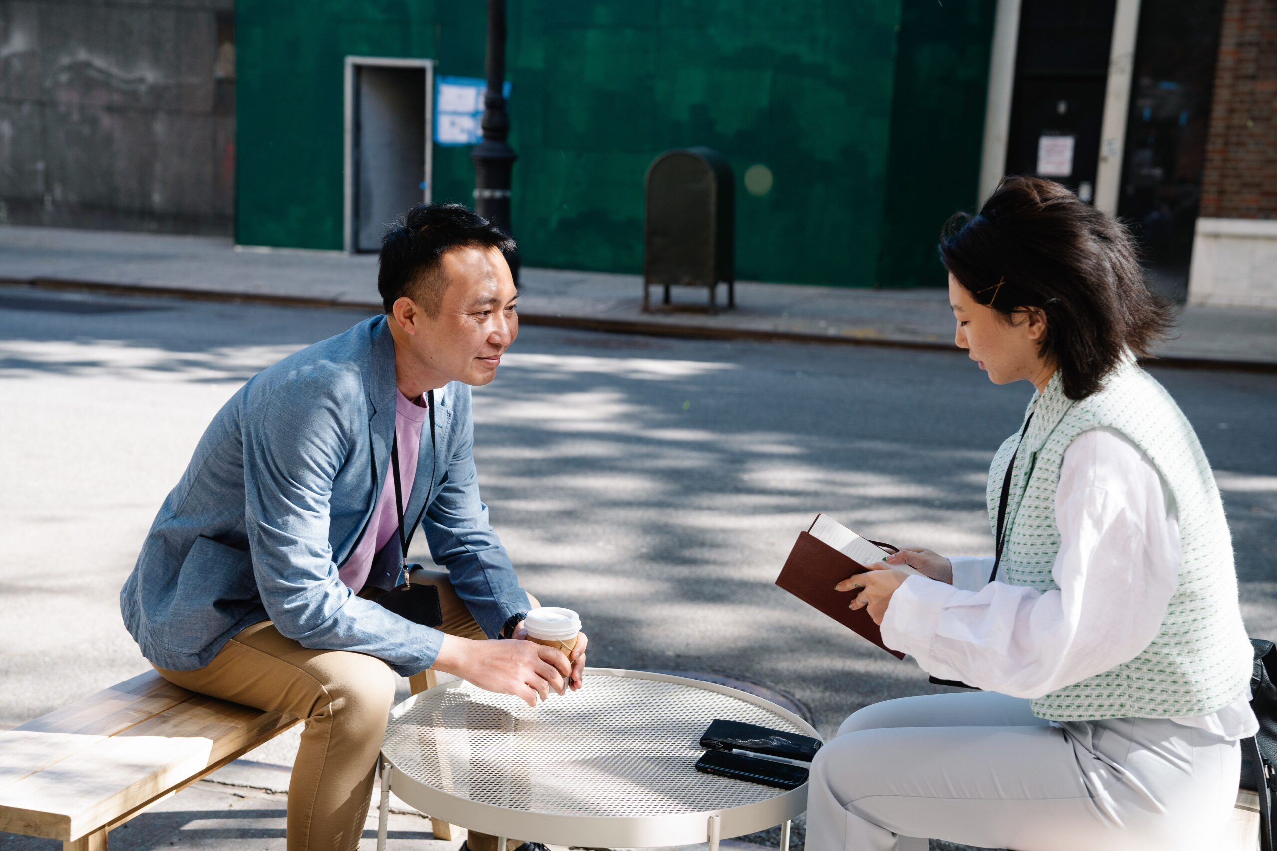 Two creative writers talking over coffee with an open notebook on the table