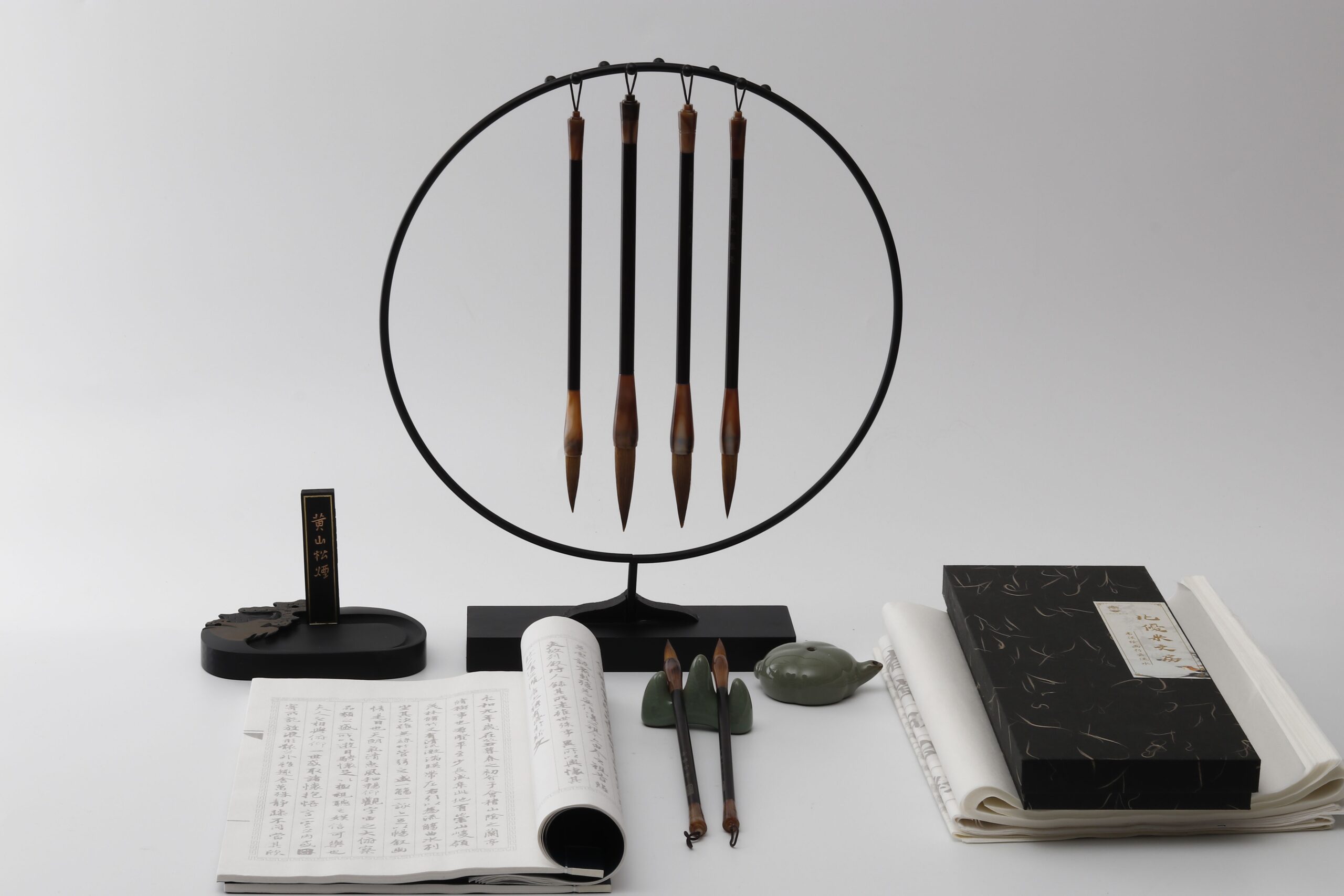 A traditional Japanese calligraphy brush and ink paper resting on a wooden desk.