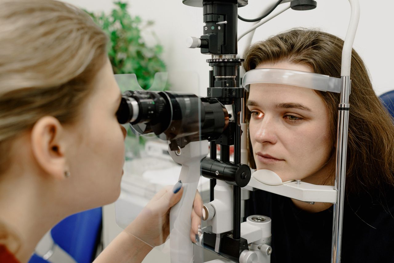 Optometrist evaluating a patient's trial contact lens fit using a slit-lamp microscope.