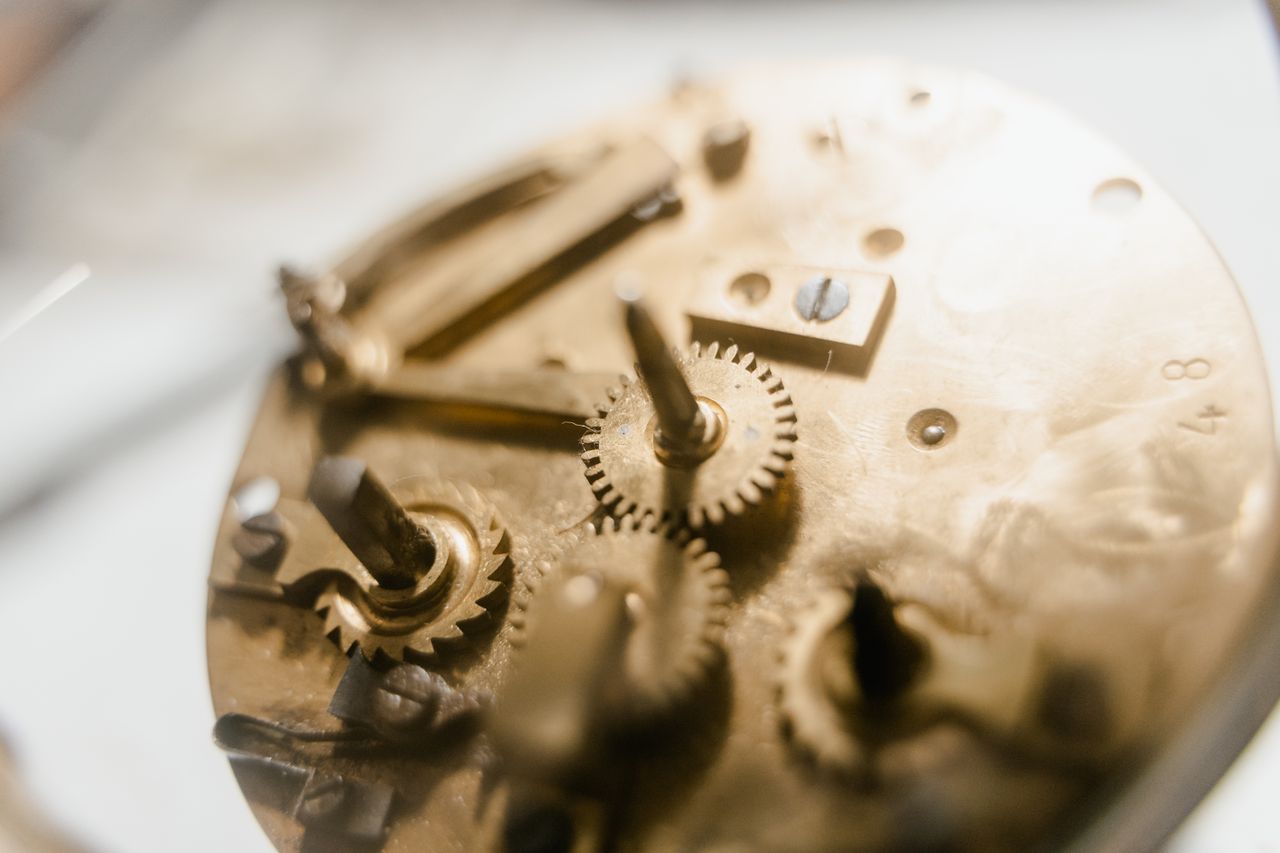 Close-up of brass mechanical clock gears and winding mechanism