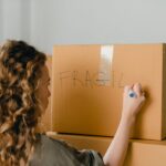 Woman labeling a fragile box during a relo g process