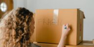 Woman labeling a fragile box during a relo g process
