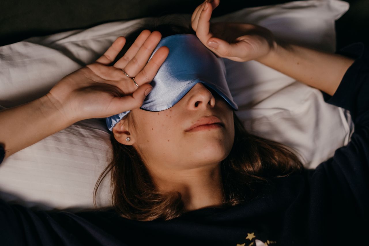 Person applying a cool compress over closed eyes for relief
