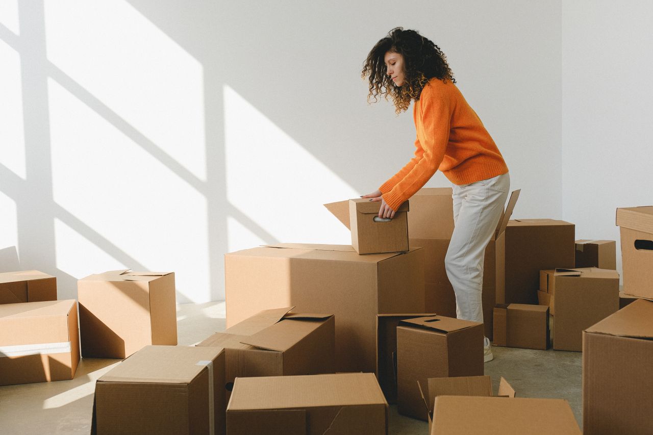 Family sitting on covered couch in new home with moving boxes