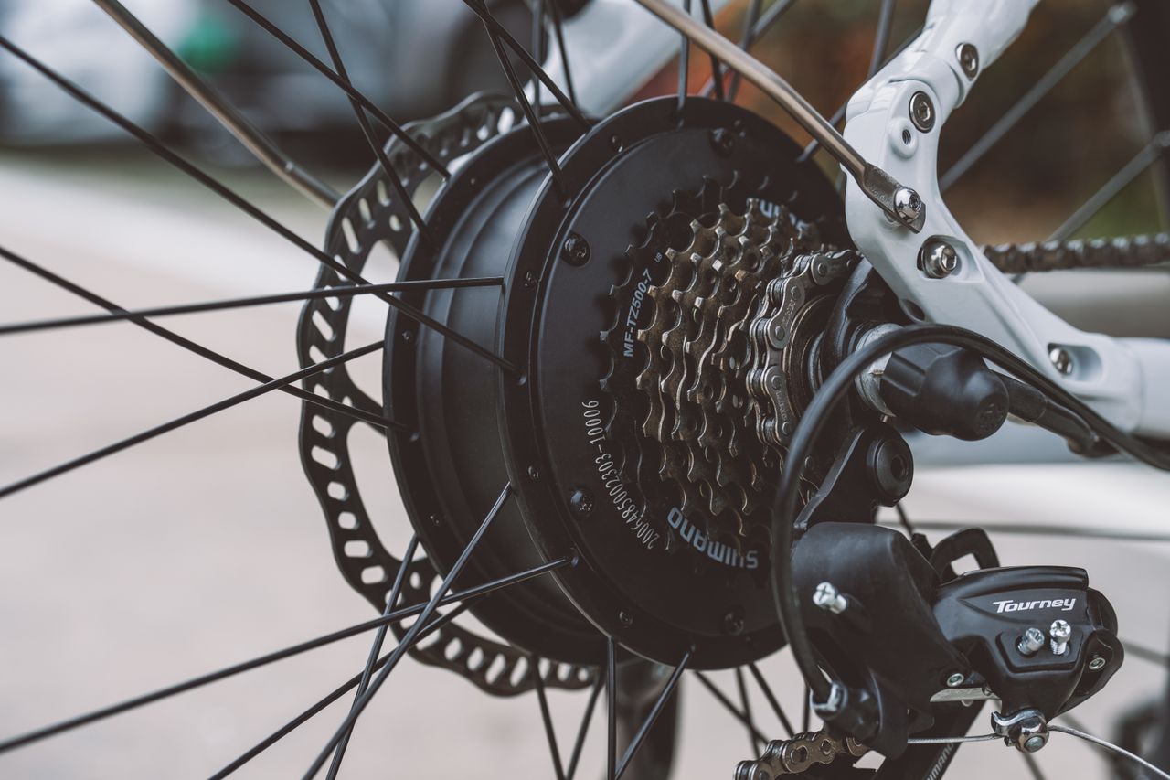 Close-up of an electric bike rear wheel hub motor and disc brake.