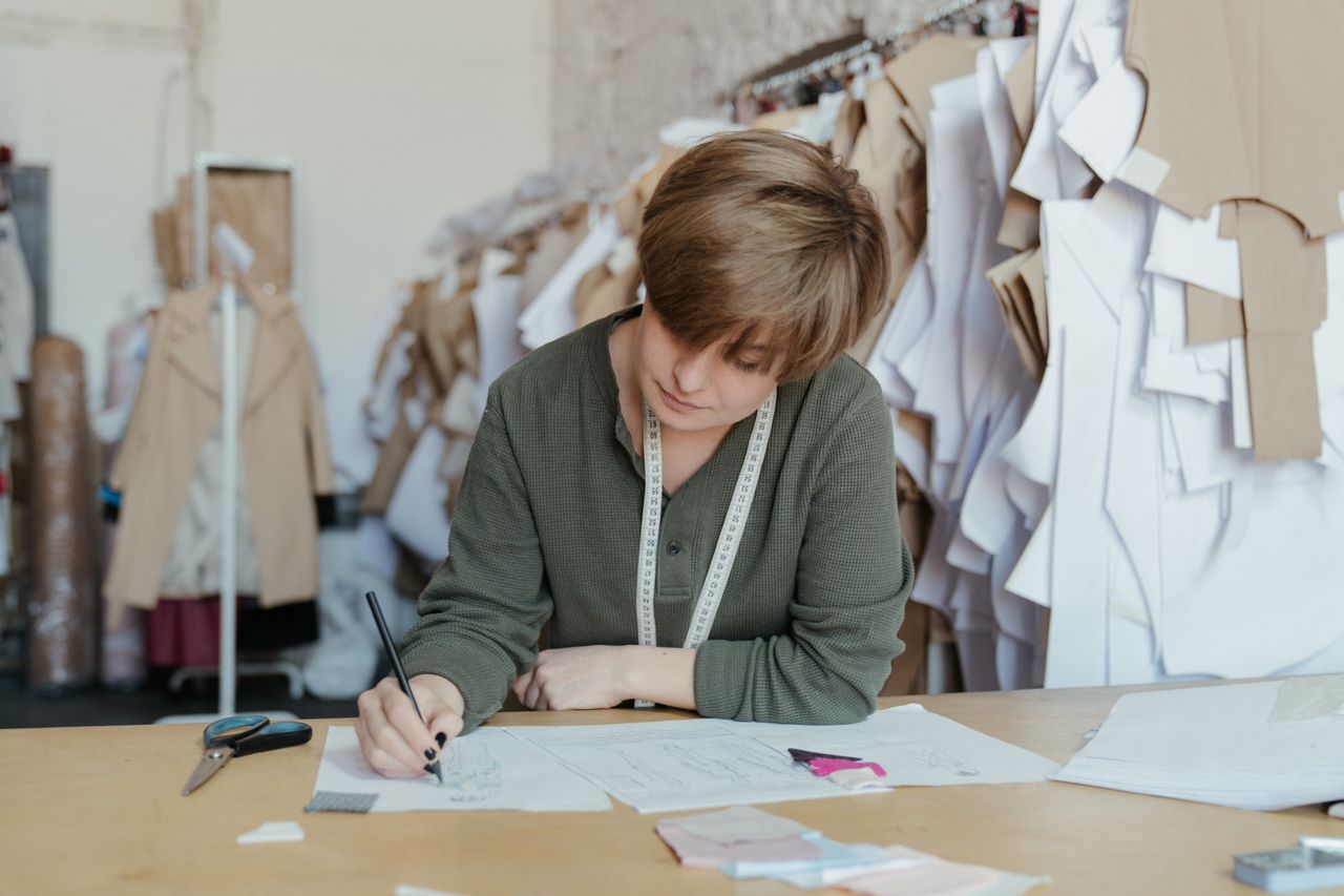 a designer sketching or working with fabric in a studio