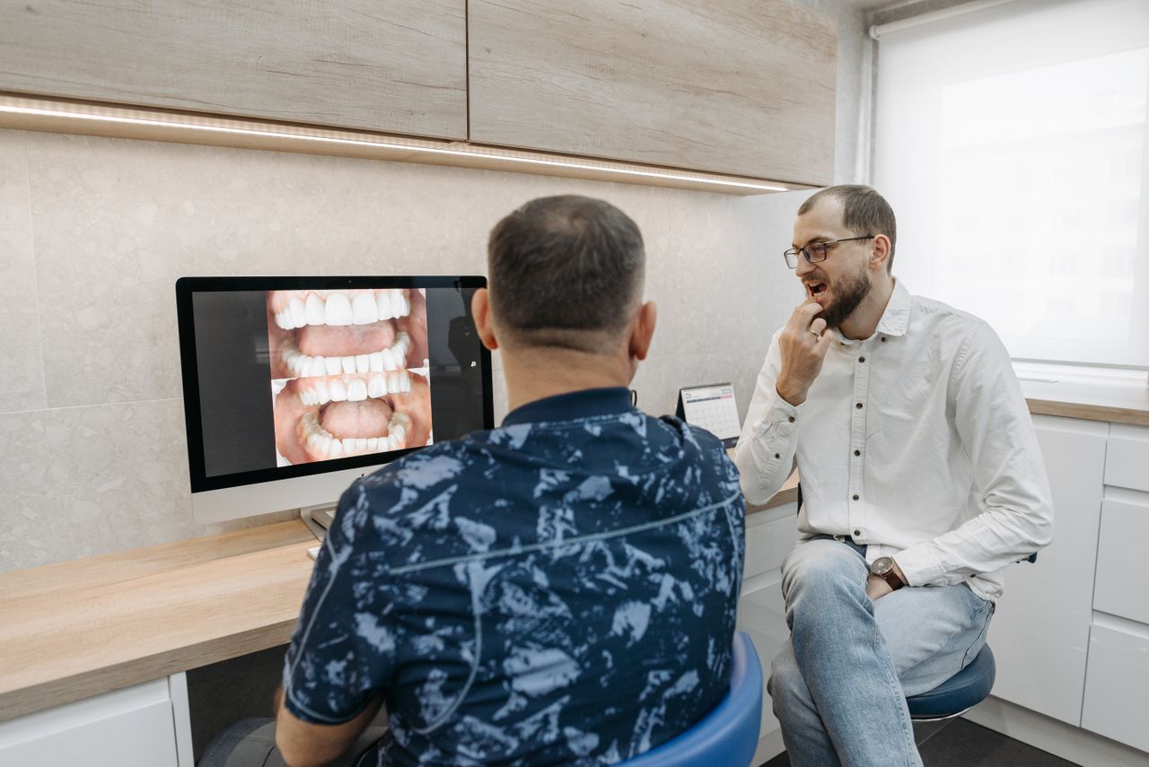 Patient reviewing dental images on a computer screen during a consultation with a dentist
